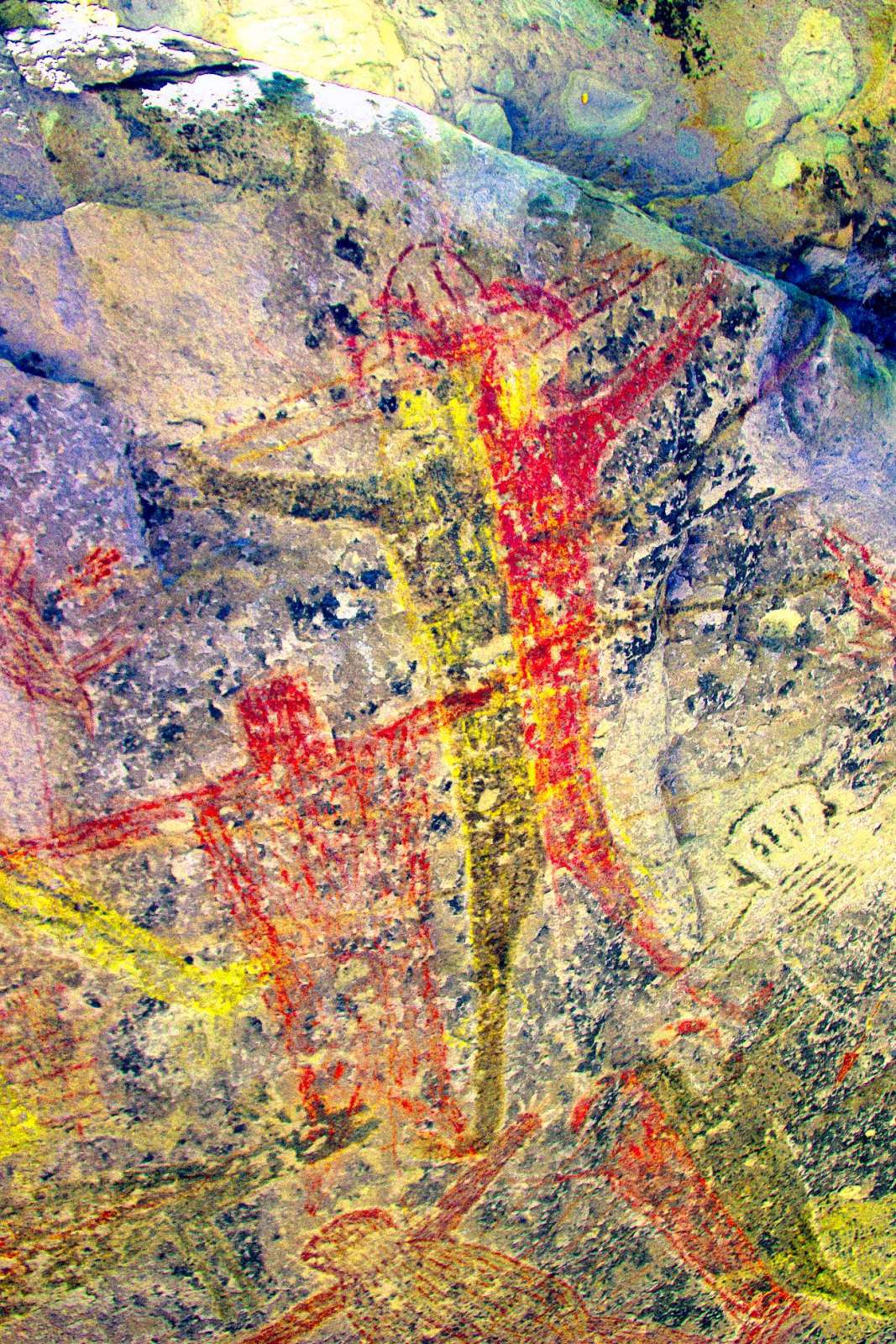 Underneath is a yellow scarecrow with a red head that extends above the red/black mono's headdress. The left arm is yellow-brown, the other is red-brown.  Later slides have clearer examples of scarecrows. (LDS)